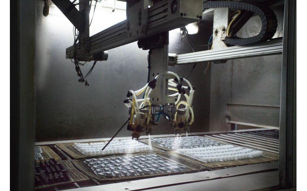 Automated screen printing machine applying graphic layouts to custom rubber components.