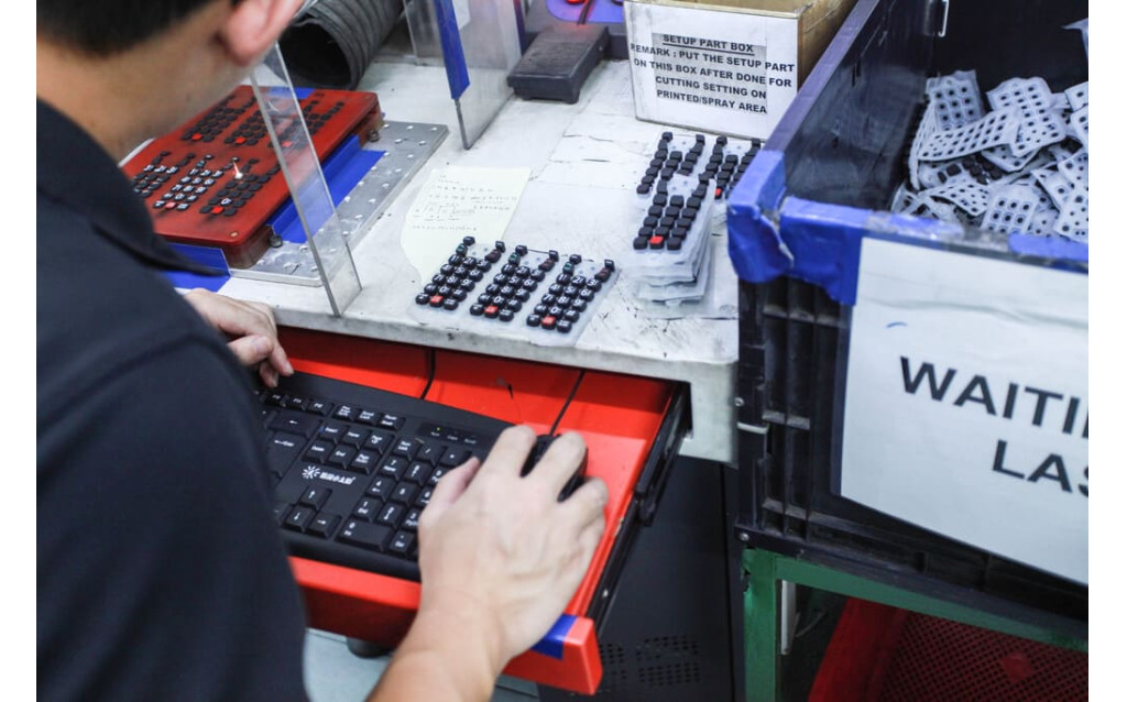 High-precision laser etching machine processing custom symbols onto a silicone rubber surface.